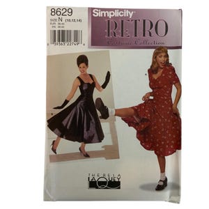 Puede incluir: Patrón de costura Simplicity Retro Costume Collection. El patrón presenta a dos mujeres con vestidos vintage. El número de patrón es 8629, con tallas N (10, 12, 14). El patrón incluye el texto "THERESA LAQUEY".