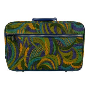 May include: A rectangular suitcase featuring a vibrant, abstract leaf-like pattern in shades of green, blue, and yellow. The luggage has a solid blue top handle, blue trim along the edges, and a horizontal silver metal zipper across the front.