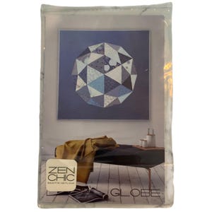 May include: A package featuring a geometric design in shades of blue, gray, and white. The package includes the text "ZEN CHIC" and "GLOBE". The design is a modern, abstract representation of a globe.