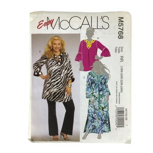 Op de afbeelding: McCall's M5768 naaipatroon-envelop met illustraties van drie tuniek- en jurkvariaties. De ontwerpen omvatten een tuniek met zebramotief, een magenta top met decoratieve halslijn en een blauw en groen bedrukte maxi-jurk.
