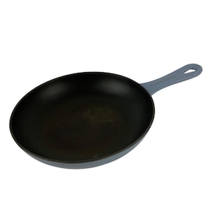 May include: A round frying pan with a matte black interior cooking surface and a light blue exterior. The pan features a single integrated handle with a hole at the end for hanging, and the brand name is embossed on the handle surface.