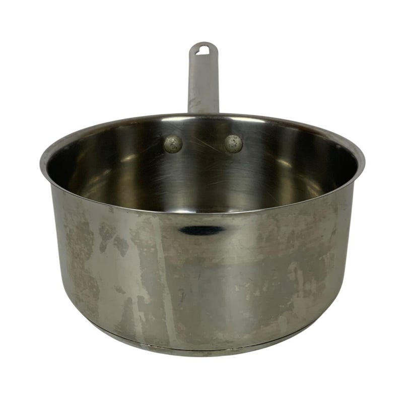 Op de afbeelding: Een roestvrijstalen steelpan met &eacute;&eacute;n handvat. De pan heeft een afgeronde body en een klein handvat met een gat om op te hangen. Het metaal heeft een geborstelde afwerking en enkele slijtplekken.