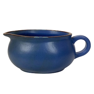 以下が含まれることがあります： 丸みを帯びたボディ、注ぎ口、ハンドルが付いた青いセラミック製のグレービーボート。縁は濃い青色です。グレービーボートは単色で、マットな仕上がりです。ハンドルはループ状です。