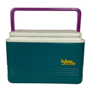 May include: A teal Igloo Legend 12 cooler with a white lid and a purple handle. The cooler has horizontal ridges near the bottom and the Igloo Legend 12 logo in yellow.