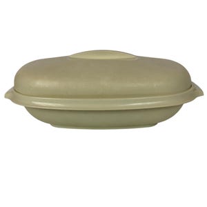 Puede incluir: Un recipiente ovalado de color beige claro con una tapa a juego. El recipiente tiene una base redondeada y un centro ligeramente elevado en la tapa. El diseño es simple y funcional, lo que sugiere un plato para guardar o servir alimentos.