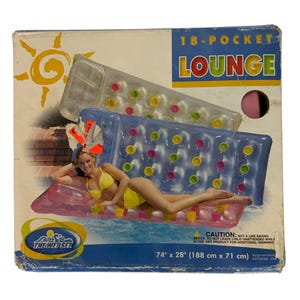 May include: An 18-pocket lounge float in a box. The box features a woman in a yellow bikini lounging on a pink float. The float is blue with colorful pockets. The text "18-POCKET LOUNGE" is visible. The float measures 74" x 28".