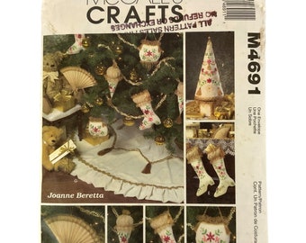 May include: A vintage McCall's Crafts sewing pattern for making Christmas ornaments. The pattern includes instructions for making a Christmas tree, stockings, a fan, and a tree skirt. The pattern number is M4691.