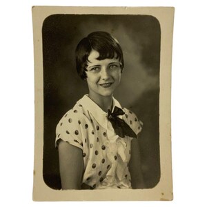 Retrato vintage en blanco y negro de una chica con blusa de lunares y corte pixie, años 20