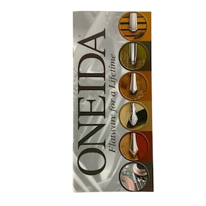 May include: A brochure for Oneida flatware, featuring the company logo and a variety of silver cutlery designs. The text reads "Oneida Flatware for a Lifetime."