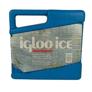 May include: A blue plastic Igloo Ice reusable ice substitute block with a handle. The front features a label with the text "igloo ice," "Reusable Ice Substitute," and "Freezes colder and stays colder than ice with no watery mess."