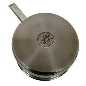 Op de afbeelding: Rvs steel pan met een lange handgreep. De bodem van de pan heeft het "Wolfgang Puck's Cafe Collection" logo en de tekst "Made in China 012007 18/10 Stainless Steel."