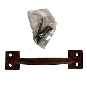 Puede incluir: Una manija de puerta de metal marrón oxidado con extremos cuadrados y dos agujeros en cada extremo. La manija se empaqueta con tornillos.
