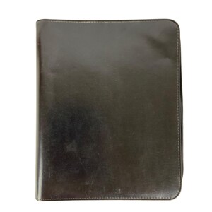 May include: A dark brown rectangular portfolio case with a smooth, polished finish and rounded corners. The case features a full-length zipper closure along the right side, providing a secure way to store documents or a notebook inside.