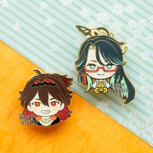 May include: Two enamel pins featuring anime characters. The first pin is a green and white character with glasses and a red bow. The second pin is a red and brown character with red eyes. Both pins have the text "sugr studio" on them.