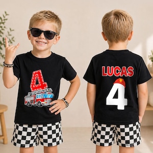 May include: A black t-shirt featuring a red number 4 and a fire truck graphic on the front, with the name LUCAS, a red firefighter helmet, and the number 4 printed on the back. The shirt is paired with black and white checkered shorts.