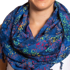 May include: A blue cotton scarf with a colorful floral pattern. The scarf has fringe on the ends.