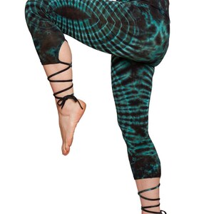 Batik Lace-Up Leggings – Seitenansicht in Yoga-Pose, Schwarz-Grün Tie-Dye-Muster, flexible Passform