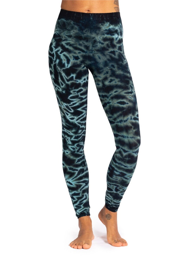 May include: Full-length leggings with a tie-dye pattern in shades of teal and navy blue. The leggings are form-fitting and made of a soft, stretchy material. The tie-dye design creates a unique, artistic look.