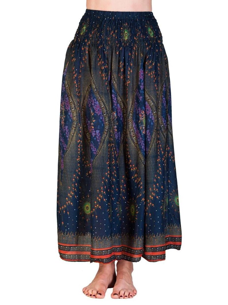May include: A long, flowing skirt with a dark blue background and an intricate paisley pattern in shades of purple, gold, and orange. The skirt has a smocked waistband and a decorative border at the hem. The skirt is made of a lightweight fabric.