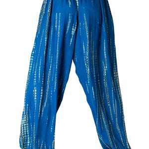 Weite blaue Relaxhose mit türkisfarbenem vertikalem Tie-Dye-Design, elastischer Bund und Knöchelbündchen, Rückansicht.