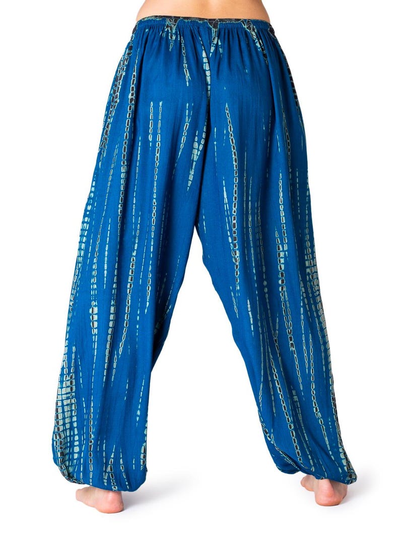 Weite blaue Relaxhose mit türkisfarbenem vertikalem Tie-Dye-Design, elastischer Bund und Knöchelbündchen, Rückansicht.