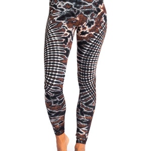 May include: Brown, black, and white patterned leggings with a tie-dye design. The leggings are fitted and have a high waist.
