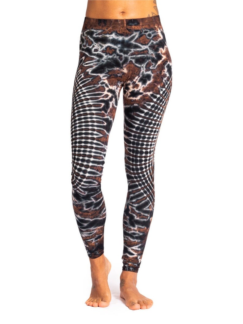 May include: Brown, black, and white patterned leggings with a tie-dye design. The leggings are fitted and have a high waist.