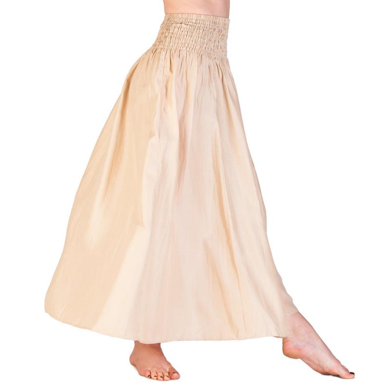 K&ouml;nnte beinhalten: Ein langer, flie&szlig;ender Rock in hellem Beige. Der Rock hat einen gerafften Bund und eine volle, ausgestellte Silhouette. Der Stoff scheint leicht und f&uuml;r warmes Wetter geeignet zu sein.