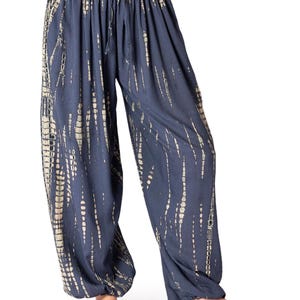 Dunkelgraue Loungehose mit beige vertikalem Tie-Dye-Muster, elastischer Bund und Knöchelbündchen, gerade geschnitten.