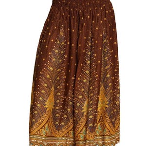 May include: Brown palazzo pants with an elastic waistband and a decorative peacock feather pattern. The pants feature a repeating pattern of gold and teal accents on a brown background. The bottom hem has a detailed border.