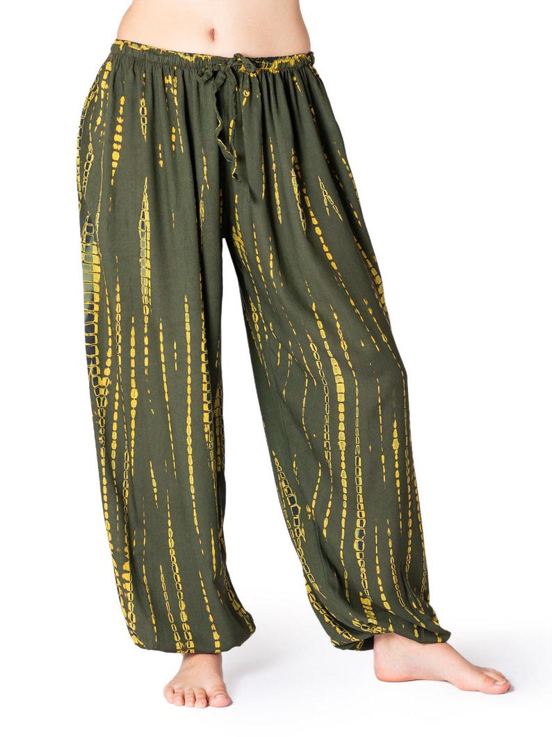 Olivgrüne Haremshose mit gelbem vertikalem Tie-Dye-Design, elastischer Bund und Knöchelbündchen, gerade geschnitten.
