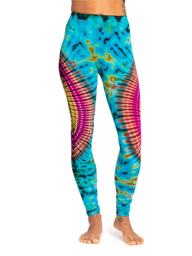 May include: Blue leggings with a colorful tie-dye pattern. The pattern features a large circle with pink, yellow, and orange hues.