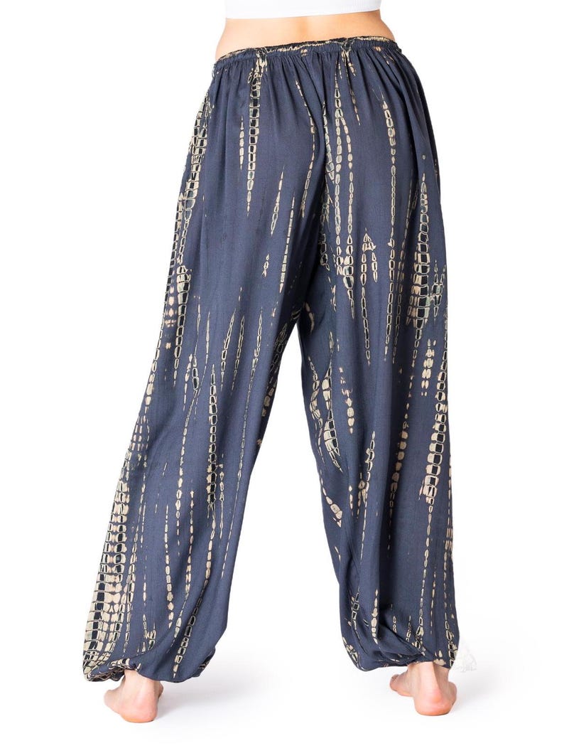 Locker geschnittene dunkelgraue Tie-Dye-Stoffhose mit elastischem Bund und Knöchelbündchen, Rückansicht.