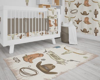 May include: A white crib with brown bedding and a matching patterned blanket featuring cowboy boots, steer skulls, and cacti. A rug with a similar design, including a cowboy hat, rope, and the text "WILD WEST", completes the western-themed nursery.