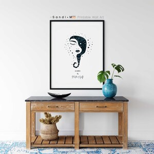 Puede incluir: Una impresi&oacute;n art&iacute;stica enmarcada con una ilustraci&oacute;n en azul oscuro y blanco de un rostro con dise&ntilde;o celestial, etiquetada como "Escorpio". La obra de arte se exhibe sobre una consola de madera con tapa negra, un jarr&oacute;n azul y un cuenco decorativo.
