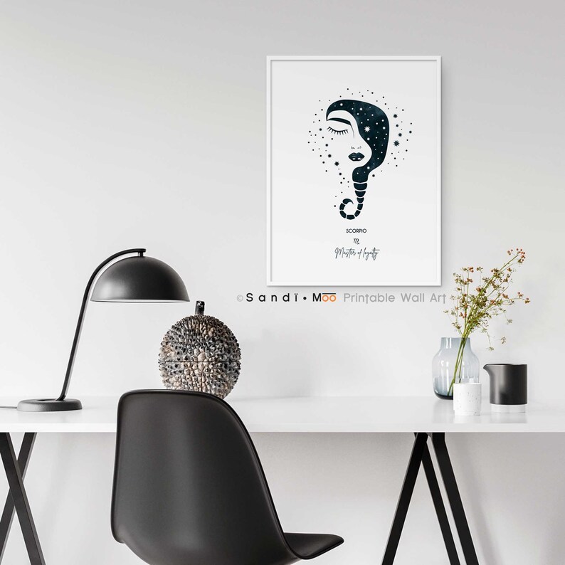 Puede incluir: Un cuadro enmarcado con una ilustraci&oacute;n estilizada del signo zodiacal de Escorpio. La obra de arte representa un rostro con los ojos cerrados y un dise&ntilde;o lleno de estrellas. El cuadro se exhibe en una pared blanca sobre un escritorio.