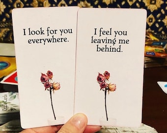 Puede incluir: Dos cartas con fondo rosa y un solo tallo de rosa seca en cada una. El texto de la carta de la izquierda dice "Te busco por todas partes". El texto de la carta de la derecha dice "Siento que me dejas atrás".