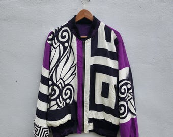 Chaqueta negra con estampado de lunares y detalles en púrpura estilo barroco de los años 90 de Versace.
