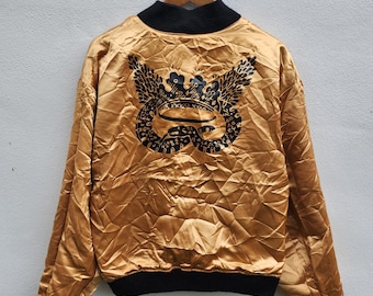 Chaqueta bomber reversible vintage de los 90 de Michiko Koshino London con estampado de serpiente negra y detalles dorados.