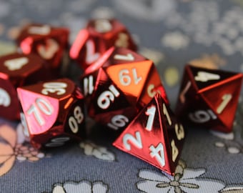 May include: A set of red and white dice with numbers 1 through 6. The dice are made of a shiny, metallic material.