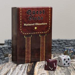 May include: A brown box with a leather texture and a yellow circle. The box has the text "Quest Decks Natural Disasters" on the front. The box is sitting on a wooden surface with two dice in front of it.