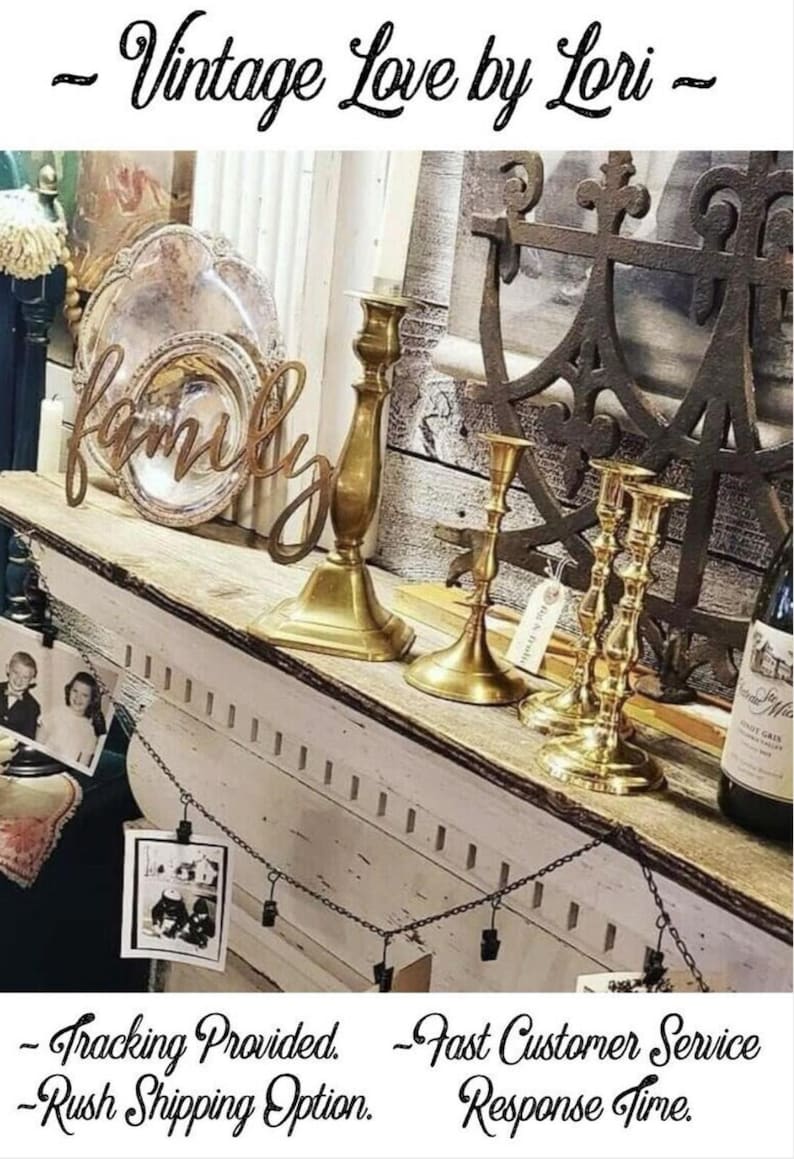 May include: A white shelf with a wooden top, decorated with vintage items, including a silver platter, candlesticks, and a metal anchor. The shelf is adorned with a wooden sign that reads "family".