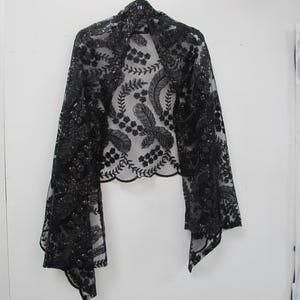 Puede incluir: Chale transparente negro con bordado de flores y plumas con lentejuelas.