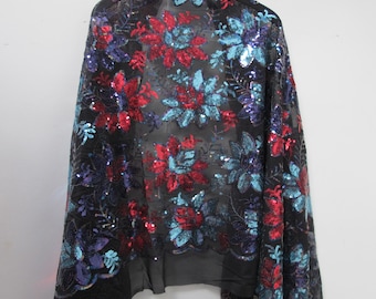 May include: Black sheer fabric with red and blue sequins in a floral pattern.