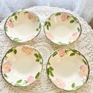 May include: Set of four white ceramic bowls with a floral design featuring pink roses and green leaves. The bowls have a scalloped edge and are perfect for serving soup, salad, or dessert.