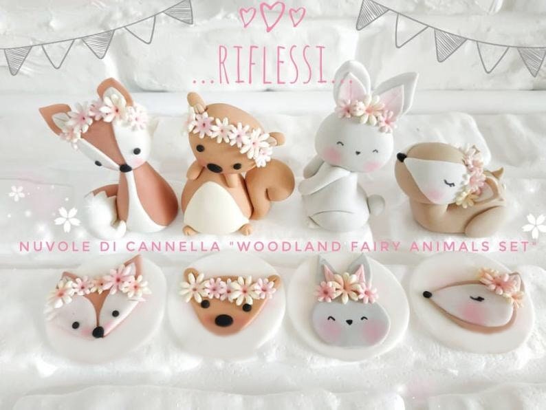 May include: Woodland fairy animal cake toppers. A set of 8 fondant toppers featuring a fox, squirrel, bunny, and deer. Each topper has a pink flower crown. The toppers are perfect for a woodland themed party.
