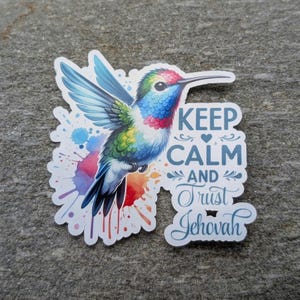 May include: A colorful hummingbird sticker with watercolor-style splashes in the background. The sticker features the text "Keep Calm and Trust Jehovah".