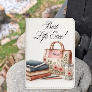 May include: A white journal cover with the text "Best Life Ever!" features a watercolor illustration of a handbag, books, pencils, and a tumbler. The handbag is decorated with pink flowers and the name "Noemi".