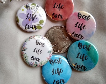 May include: Six round buttons with the text "Best Life Ever" in black script. The buttons have different backgrounds, including floral, watercolor, and solid colors.
