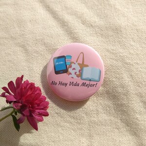 May include: Pink button with a cartoon illustration of a bag, a book, a coffee cup, and a phone with the text "jw.org". The text "No Hay Vida Mejor!" is printed below the illustration.